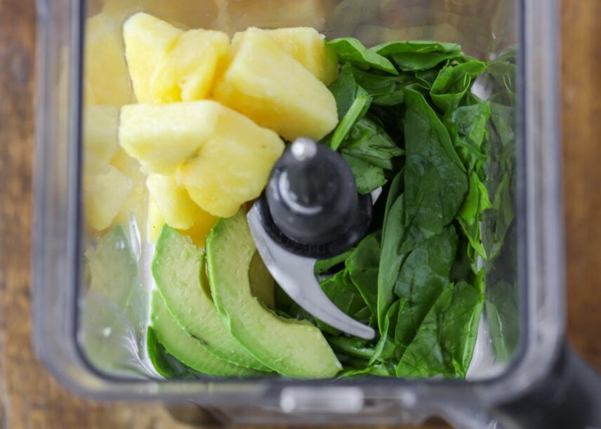 Blender full of ingredients for green smoothie recipe